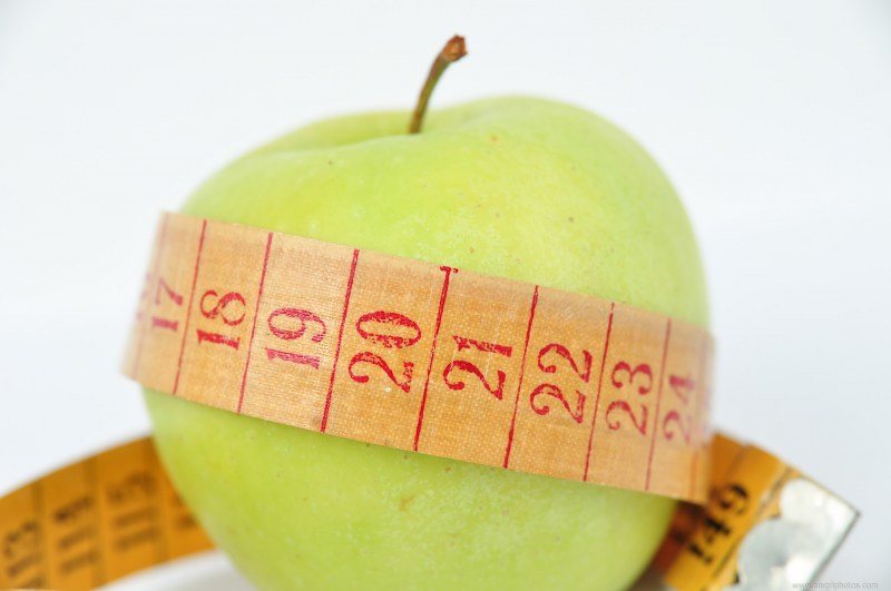 Measuring tape around green apple free photo
