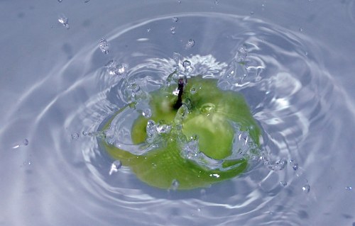 Apple splashing in water free photo