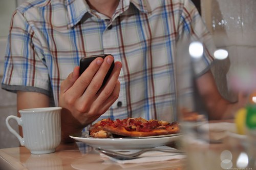 Man in restaurant checking his smartphone free photo