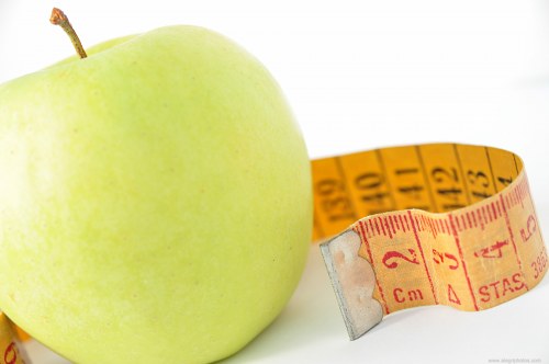 Measuring tape and green apple free photo