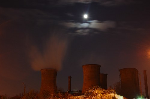Moon over a industrial area at night free photo